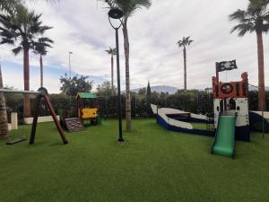 a park with a playground with palm trees and slides at Apartment in Motril near Los Moriscos Golf in Motril