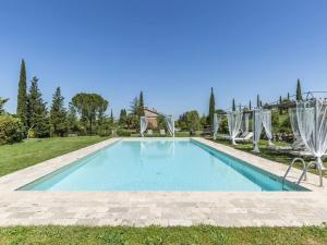 een zwembad in een tuin met twee stoelen bij Cozy Villa in Castiglione D'orcia Italy with Private Pool in Castiglione dʼOrcia