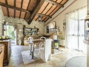 een keuken met een tafel en stoelen en een stenen muur bij Cozy Villa in Castiglione D'orcia Italy with Private Pool in Castiglione dʼOrcia