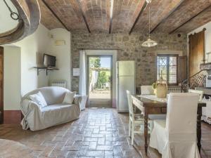 een keuken en een woonkamer met een stenen muur bij Cozy Villa in Castiglione D'orcia Italy with Private Pool in Castiglione dʼOrcia