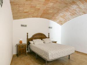 1 dormitorio con 1 cama y techo de ladrillo en Pleasant holiday home in La Vall with private pool, en La Vall