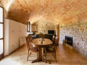 una sala da pranzo con tavolo, sedie e camino di Pleasant holiday home in La Vall with private pool a La Vall