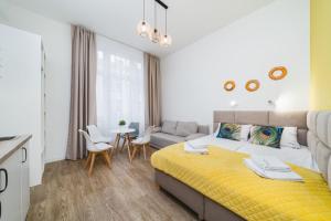 sypialnia z żółtym łóżkiem i kanapą w obiekcie Bagel Residence Old Town w Krakowie
