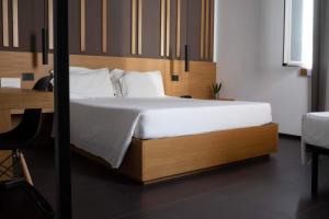 a bedroom with a large bed with a wooden headboard at Central Lodge Hotel in Rome