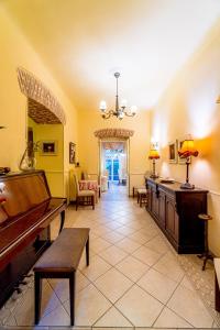 a large living room with a piano and a table at Archontiko Eleni Hotel in Andros