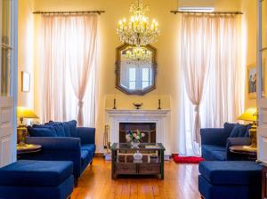 a living room with blue couches and a fireplace at Archontiko Eleni Hotel in Andros