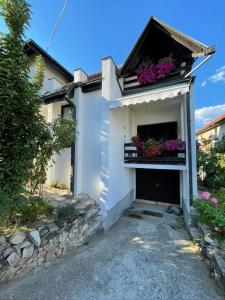 Casa blanca con flores en el balcón en Vidikovac Vrnjačka Banja, en Vrnjačka Banja