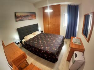 um pequeno quarto com uma cama e uma mesa em Algarve, modern T1 apartment with balcony, Quarteira em Quarteira
