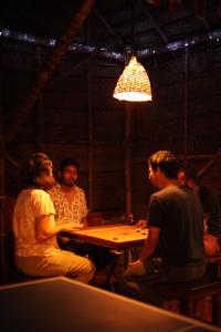 a group of people sitting at a table in a room at HostelExp, Varkala - A Beach Town Hostel in Varkala