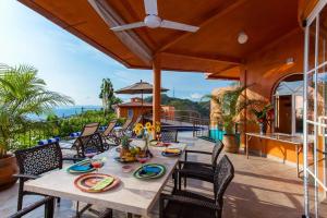 a patio with a table and chairs on a balcony at Orange Sunsets, Lush Landscape, Intown, Privacy in Puerto Vallarta