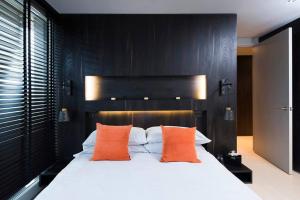 um quarto com uma cama grande e almofadas laranja em Penthouse Apartment in the Heart of London em Londres