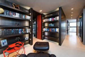 uma sala de estar com estantes de livros e uma cadeira vermelha em Penthouse Apartment in the Heart of London em Londres