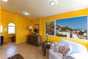 a living room with a white couch and a large window at Orange Sunsets, Lush Landscape, Intown, Privacy in Puerto Vallarta