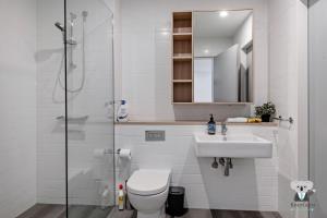 a bathroom with a toilet and a sink and a shower at KOZYGURU Penrith Cosy 2BED 2BATH APT + FREE Parking NPE081 in Penrith