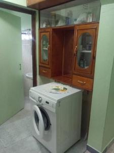 a washing machine in a kitchen with a cabinet at Greton Holiday Villa in Meru