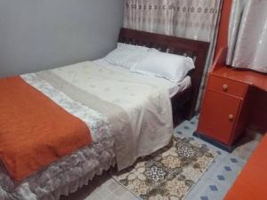 Greton Holiday Villa في Meru: غرفة نوم مع سرير وخزانة وسرير سيد