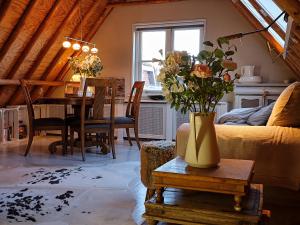 ein Wohnzimmer mit einem Tisch und einer Blumenvase in der Unterkunft JagershuisTexel in Oosterend