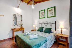 1 dormitorio con 1 cama, 2 mesas y espejo en El Nogal, en San Juan de la Rambla