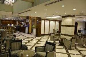 a lobby with chairs and tables and a bar at Al Jury Serviced Apartments in Al Khobar