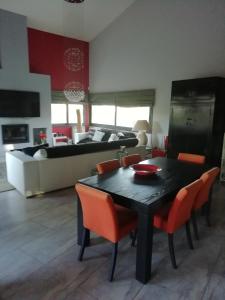 een woonkamer met een zwarte tafel en oranje stoelen bij CASA NEUS in El Arrabal de Coll dʼArbós