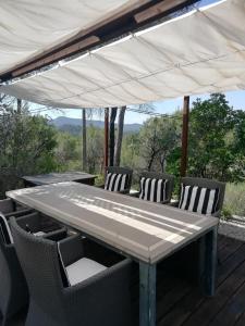 een tafel en stoelen onder een luifel op een terras bij CASA NEUS in El Arrabal de Coll dʼArbós