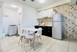 a kitchen with a white table and a refrigerator at Sunrise Soho Scott Garden in Kuala Lumpur