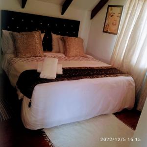een slaapkamer met een groot bed met witte lakens bij Zagorski’s Bed and breakfast in Bloubergstrand