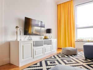 a living room with a tv on a white entertainment center at Scandinavian Apartment in Rădăuţi