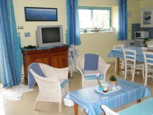 een woonkamer met een tafel en stoelen en een televisie bij Gite Le Mascaret in Roz-sur-Couesnon