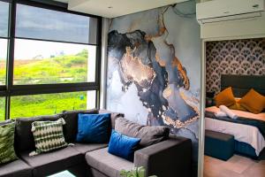 uma sala de estar com um sofá e uma cama em Zimbali Lakes Boulevard Suites 103 em Ballito