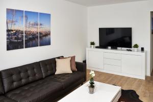 エッカーンフェルデにあるWilde 13のリビングルーム(黒い革張りのソファ、テレビ付)