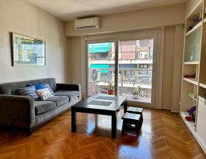Great Apartment in Recoleta في بوينس آيرس: غرفة معيشة مع أريكة وطاولة