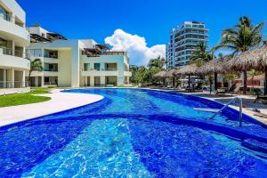 a swimming pool with blue water in a resort at PB4 Nitta in Nuevo Vallarta