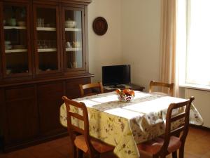 una sala da pranzo con tavolo e TV di Lidia Apartment a Riva del Garda
