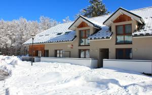 une maison avec de la neige devant elle dans l'établissement Studio aux pieds des pistes, des chemins de Rando, à Les Déserts