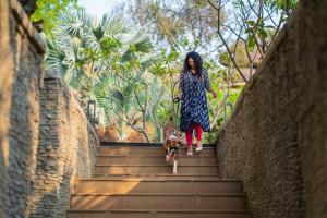 Una donna che scende le scale con un cane di Hyatt Hyderabad Gachibowli a Hyderabad