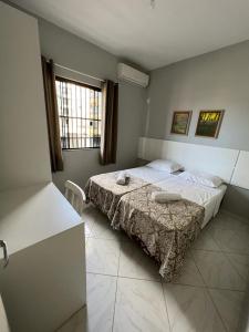 um quarto com uma cama e uma janela em Dax Bombinhas em Bombinhas