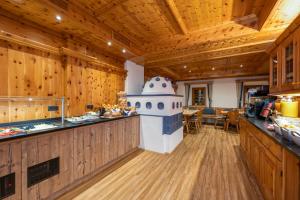 duża kuchnia z drewnianymi ścianami, drewnianą podłogą i blatem w obiekcie Aparthotel Weningeralm w mieście Obertauern