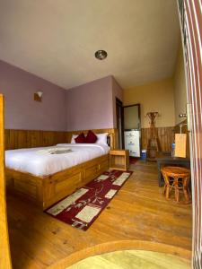 a bedroom with a large bed and a table at Gombo Hideaway in Nagarkot