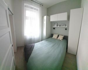 a small bedroom with a bed with a window at CS14 Gold Apartment in Budapest