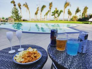 un tavolo con un piatto di cibo e due bicchieri di birra di VILLA PARADISO ACIREALE "con piscina in esclusiva o condivisa " ad Acireale