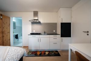 eine Küche mit weißen Schränken und einem Waschbecken im Zimmer in der Unterkunft Chalet Ruestel in Amden