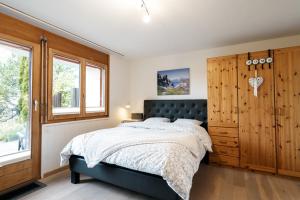 ein Schlafzimmer mit einem Bett und einem großen Fenster in der Unterkunft Chalet Ruestel in Amden