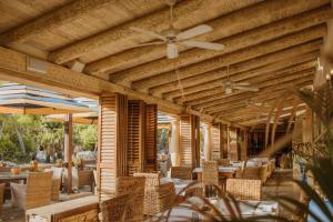 a restaurant with wooden ceilings and tables and chairs at Desert Springs Resort in Vera