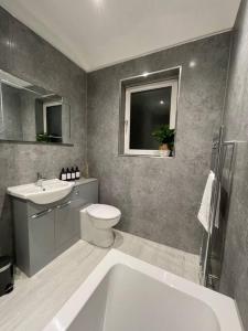a bathroom with a tub and a toilet and a sink at Stylish 3 Bed Home in Clitheroe in Clitheroe