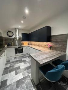 a kitchen with a counter and blue chairs in it at Stylish 3 Bed Home in Clitheroe in Clitheroe