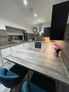 a kitchen with a large wooden table and blue chairs at Stylish 3 Bed Home in Clitheroe in Clitheroe