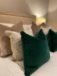 a bed with green pillows on top of it at Stylish 3 Bed Home in Clitheroe in Clitheroe