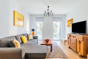 un soggiorno con divano e TV a schermo piatto di Santo Amaro Beach Apartment a Oeiras