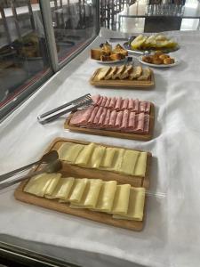 deux planches à découper avec de la viande et du fromage sur une table dans l'établissement Hotel Art Final, à Marataizes